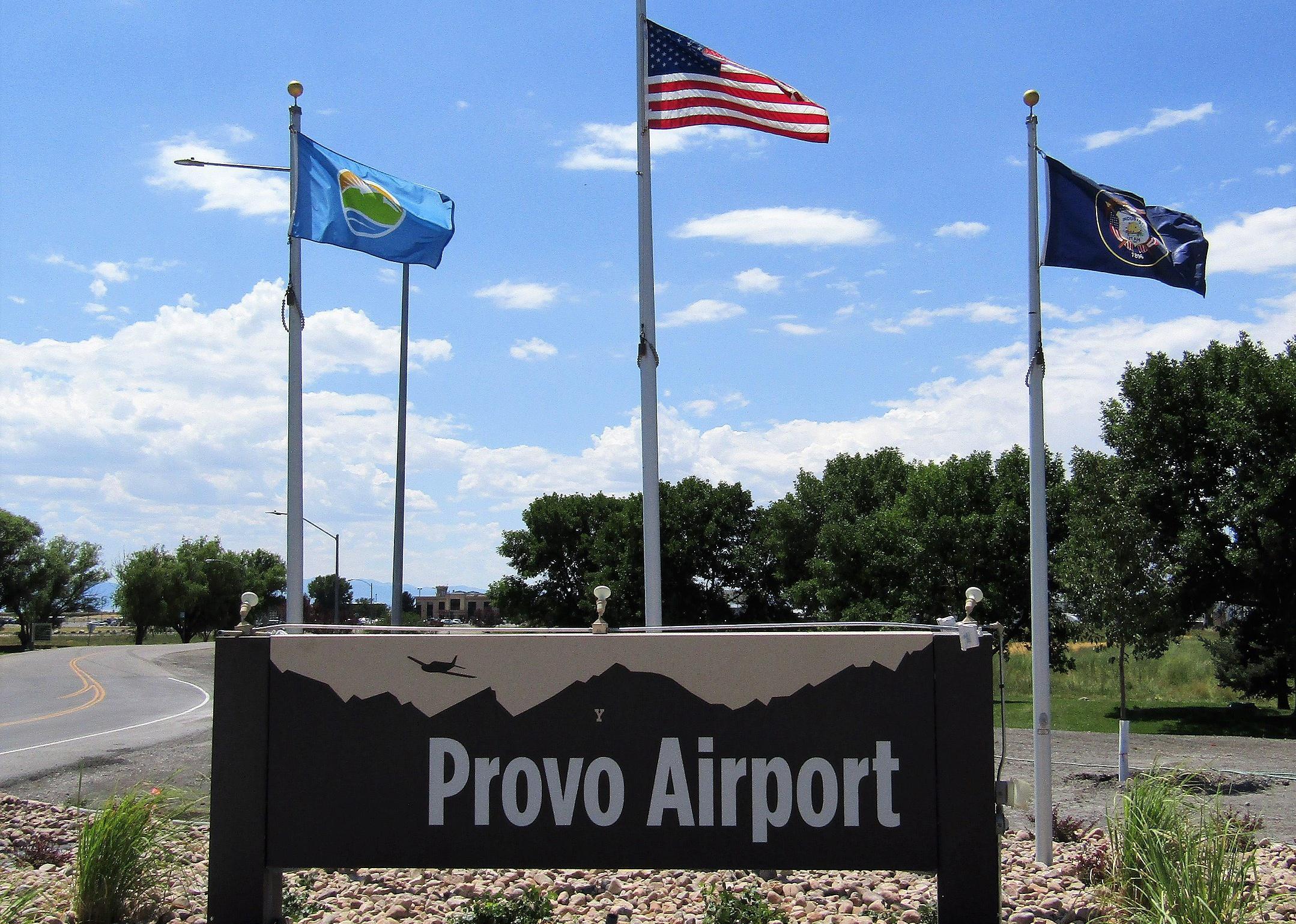 A small airport sign for Provo with flags.