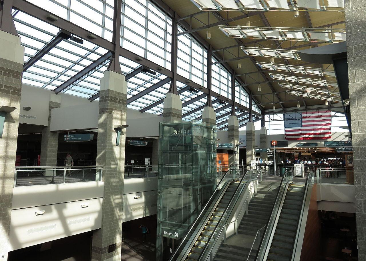 An escalator and American flag in Theodore Francis Green airport.