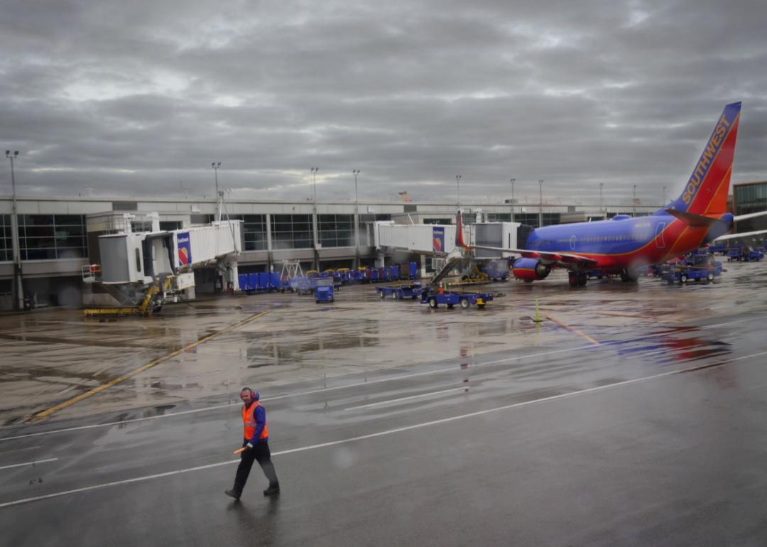 A rainy day on the tarmac with an airport worker near a Southwest jet.