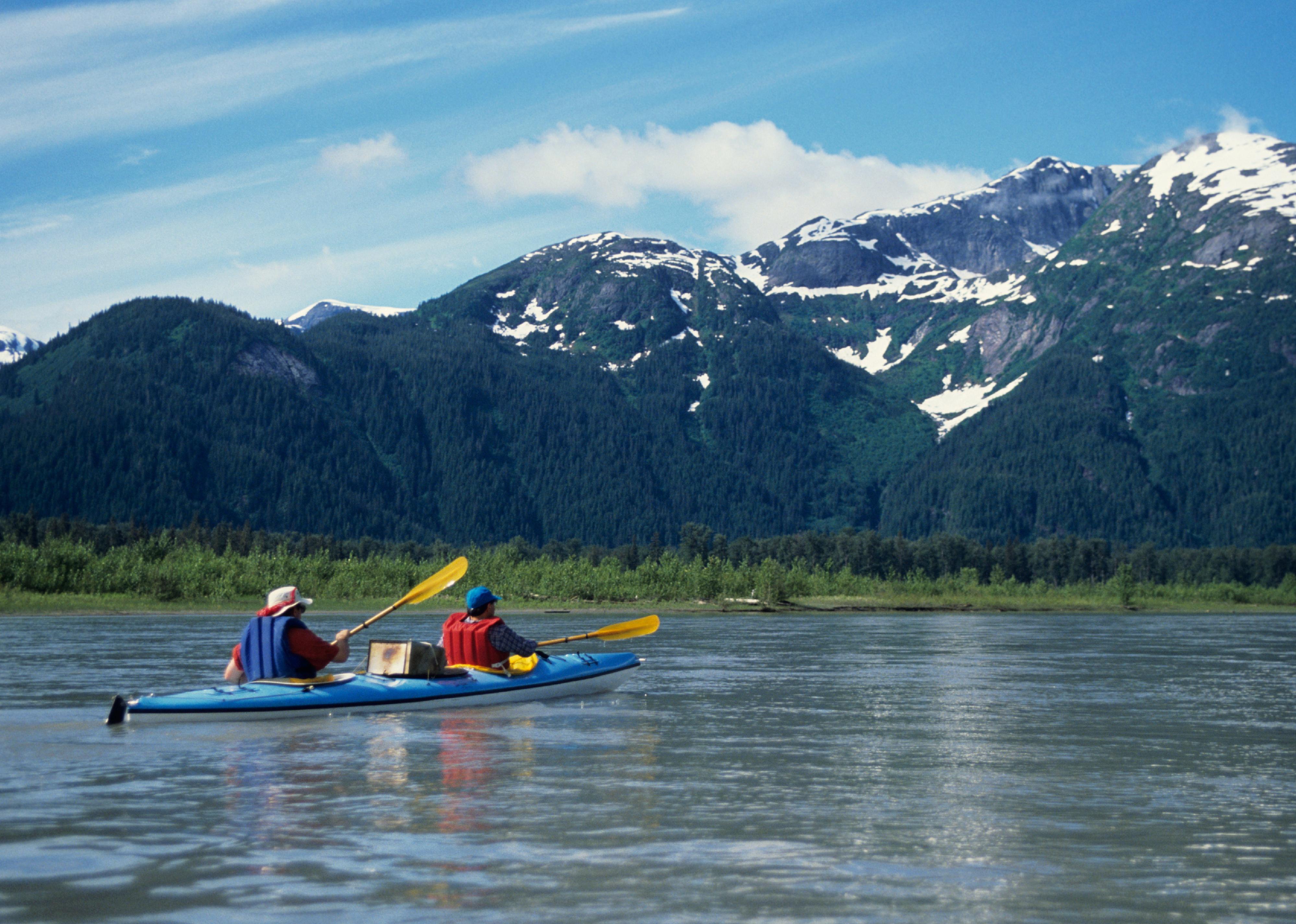 Kayakers explore calm waters in Alaska.