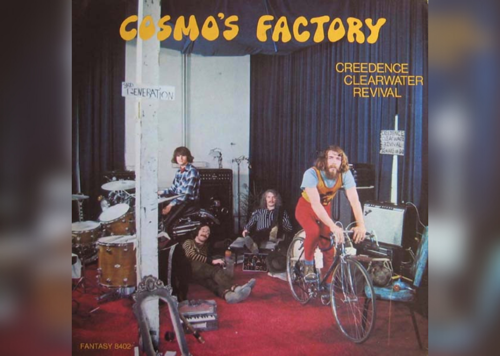 CCR sitting in a room near instruments and a man on a bicycle.