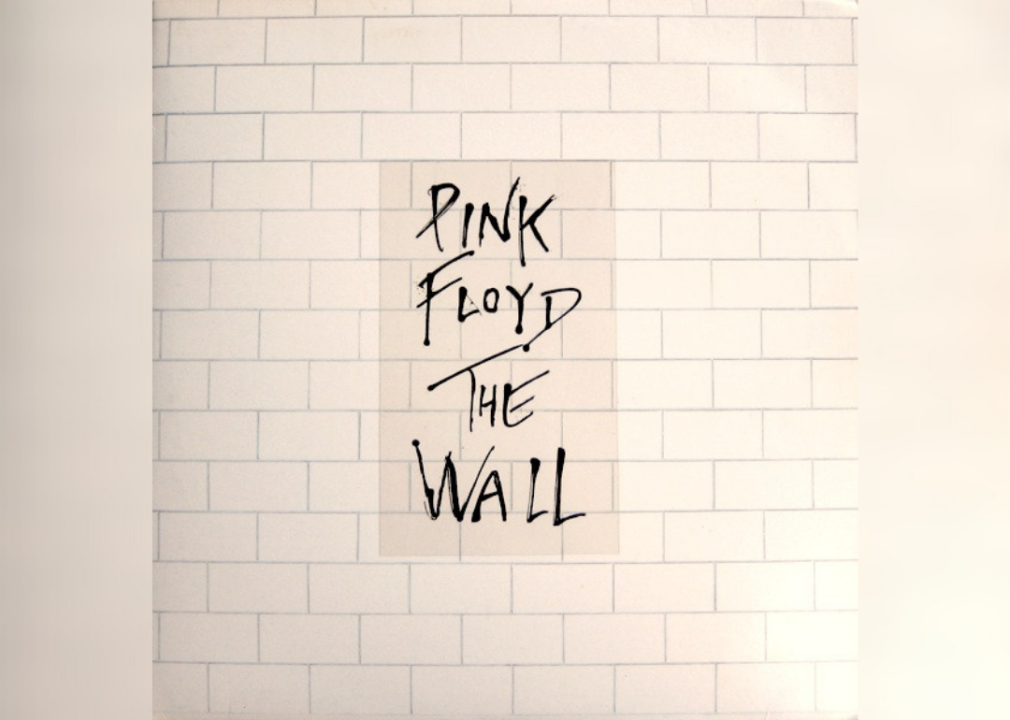 White brick wall with album name in the middle.