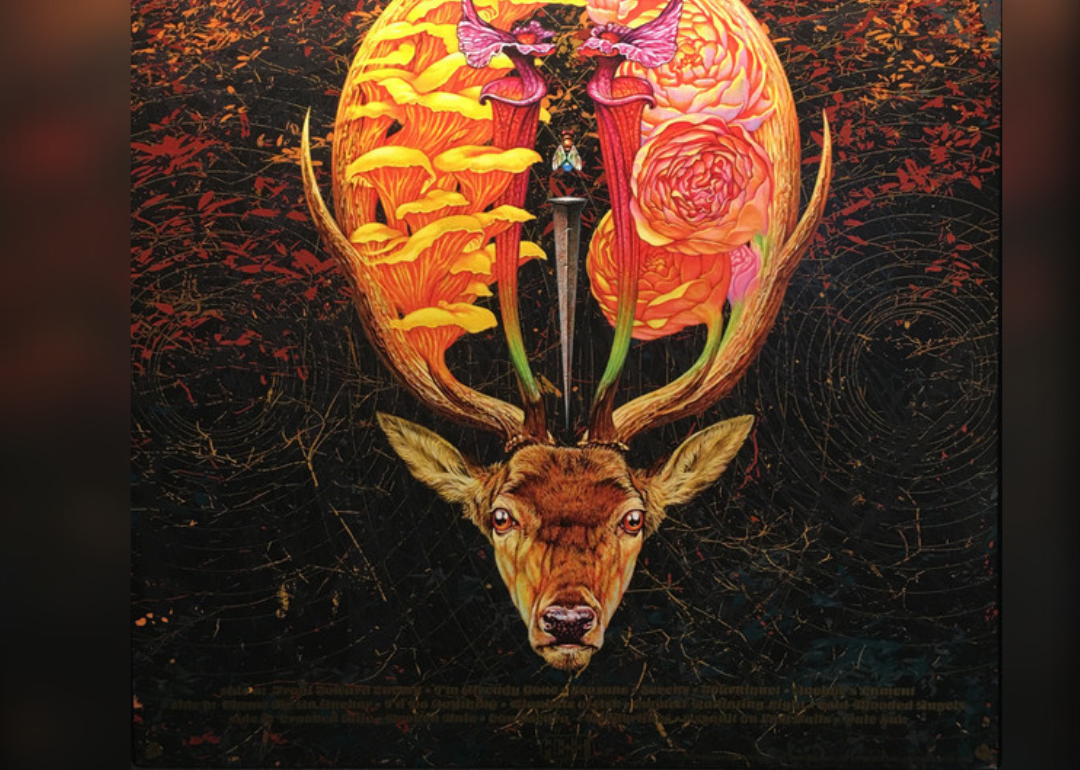 A colorful illustration of a deer head with flowers and mushrooms growing out of the antlers.