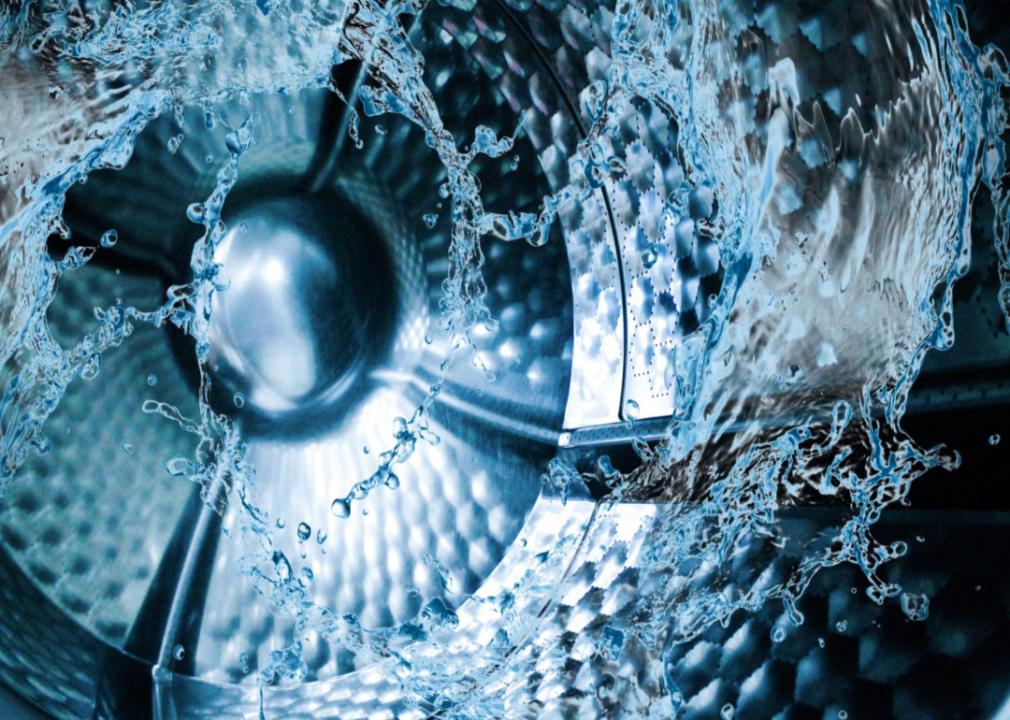 Inside of a washing machine with water splashing around.