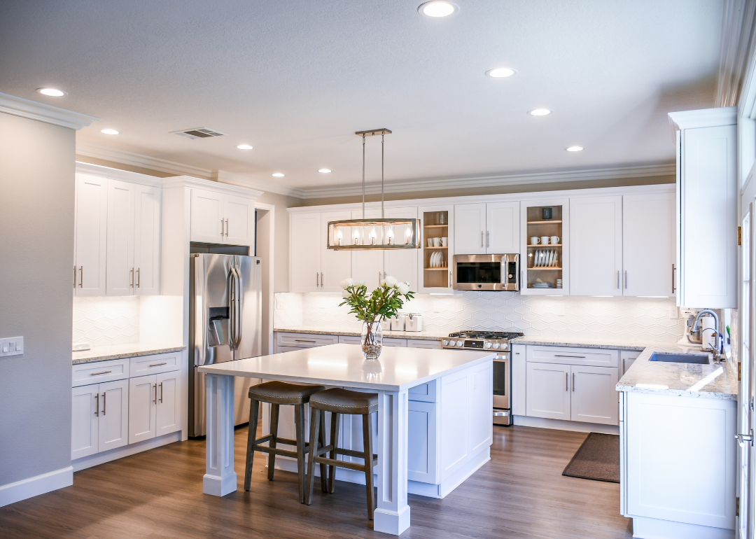 A kitchen with all white cabinets and an island.