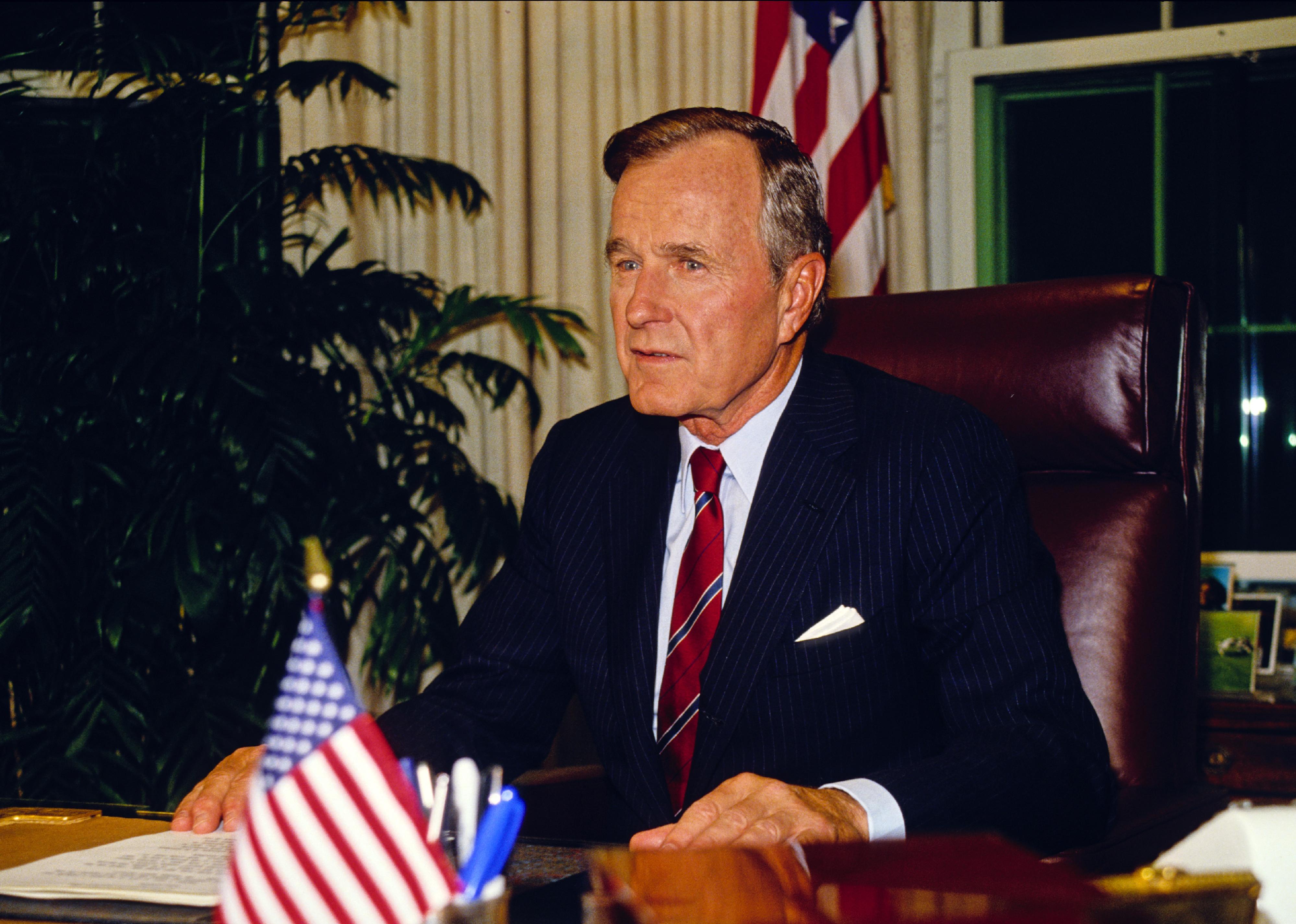George Bush behind the desk in the Oval Office at the White House.