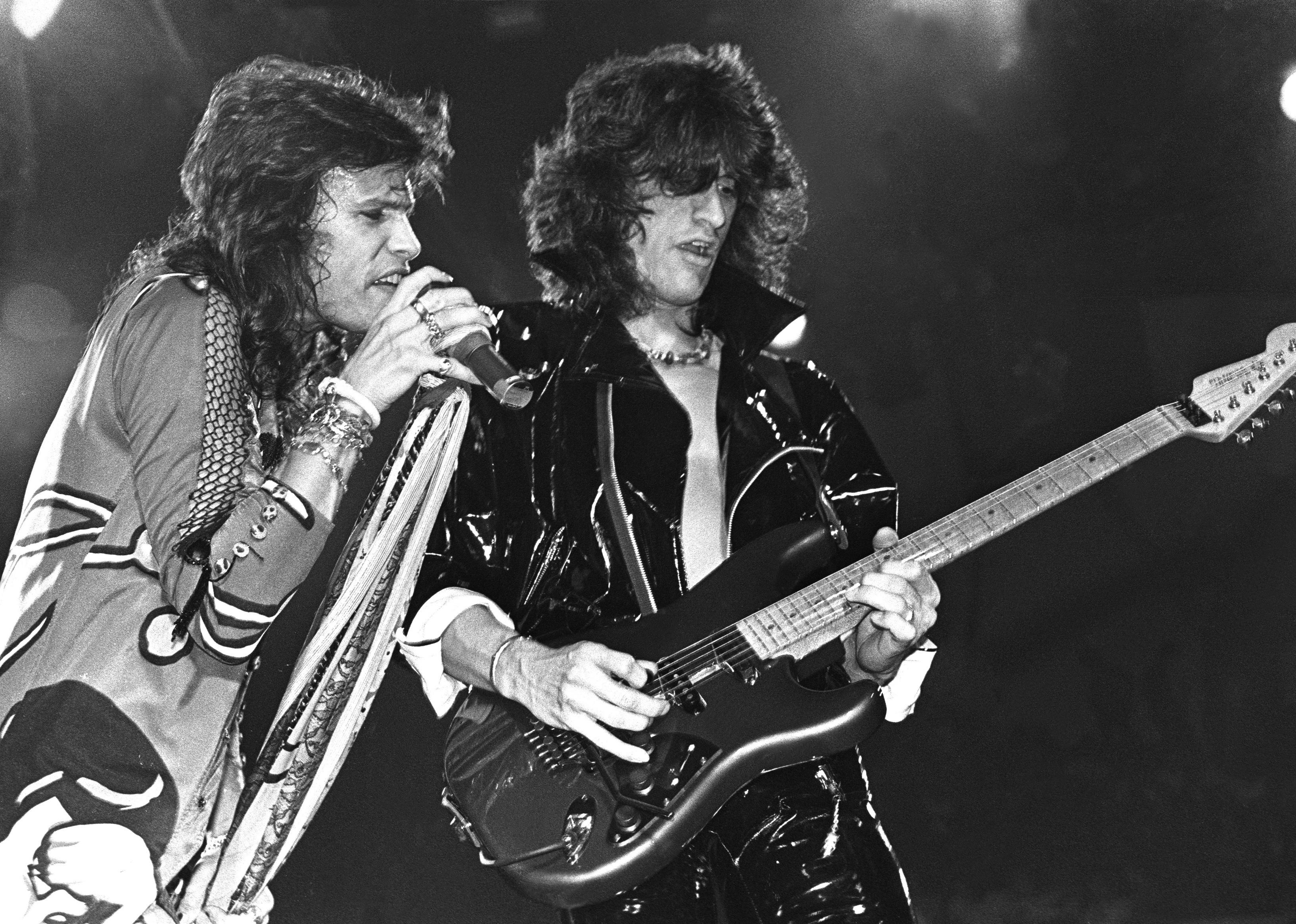 Aerosmith onstage singing and playing guitar