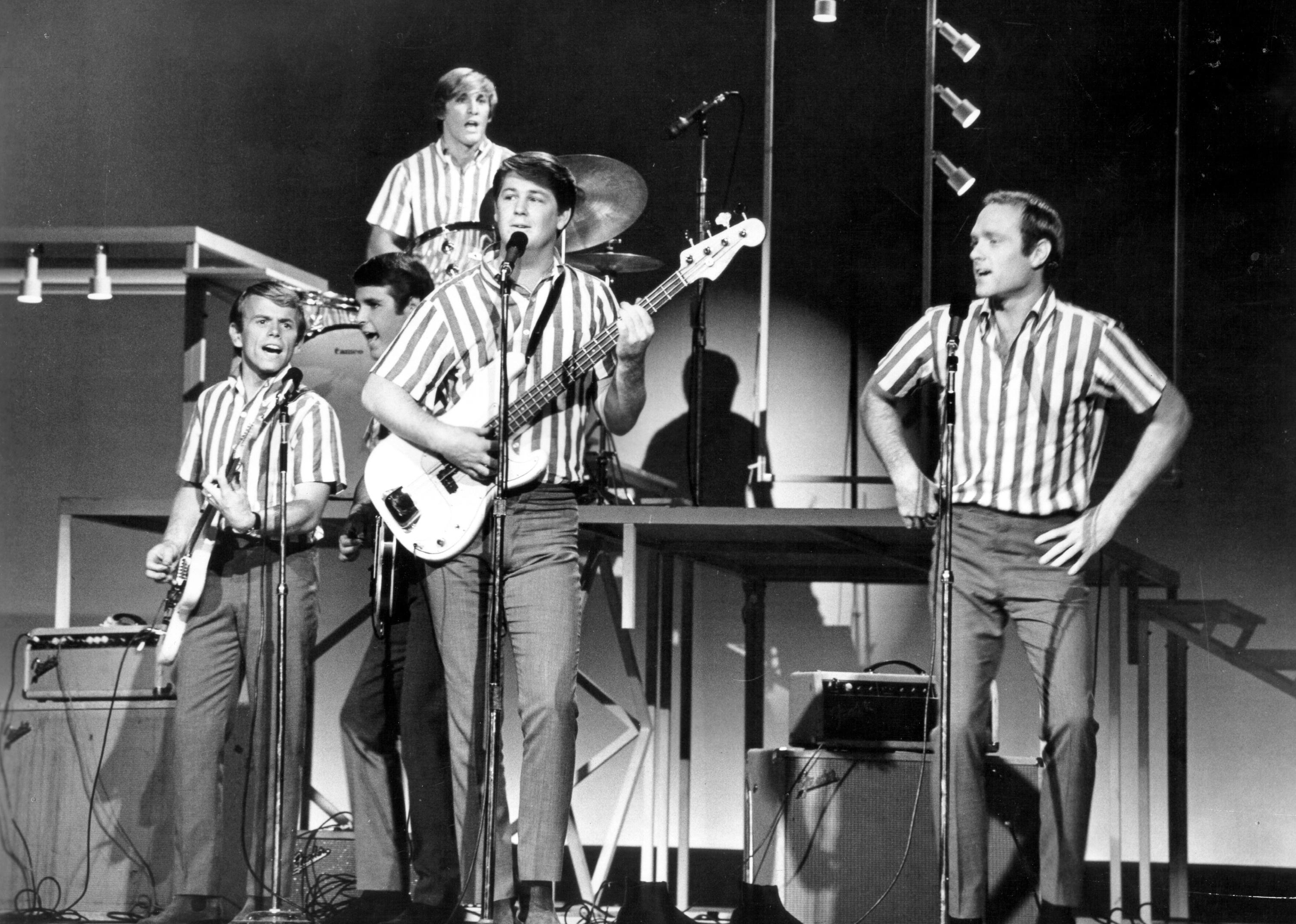 The Beach Boys onstage all dressed in striped shirts.