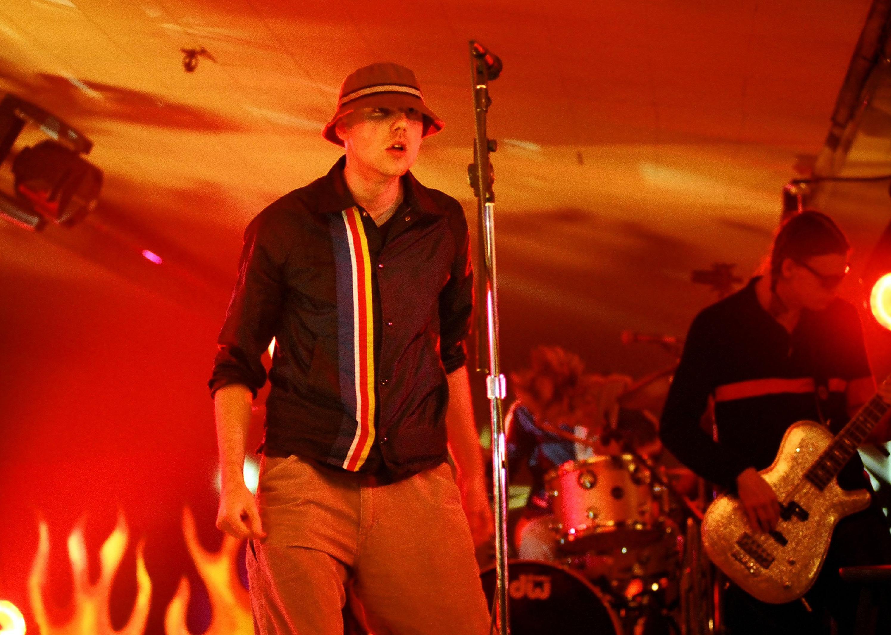 New Radicals performing onstage under a red light.