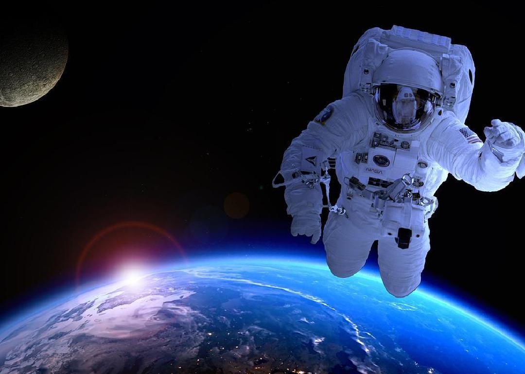 A astronaut floating in space above the earth. 