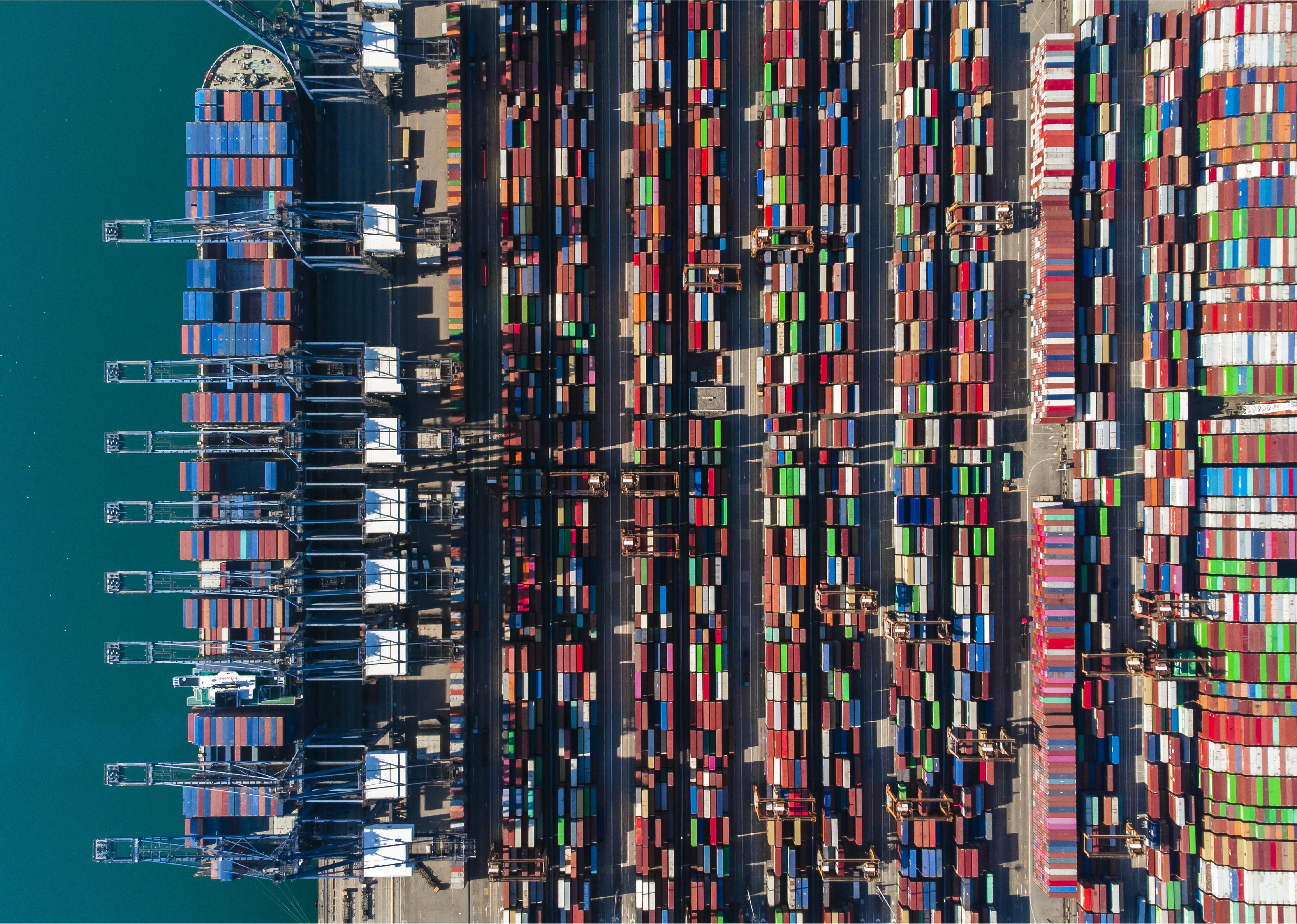 An aerial view of containers piled at a port.