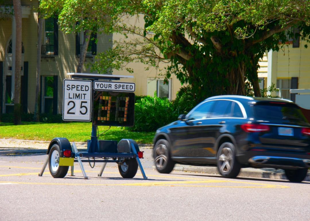 A radar detector shows a passing car's speed limit as it speeds down the road.