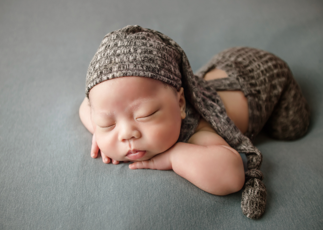 A baby in a brown outfit sleeping.