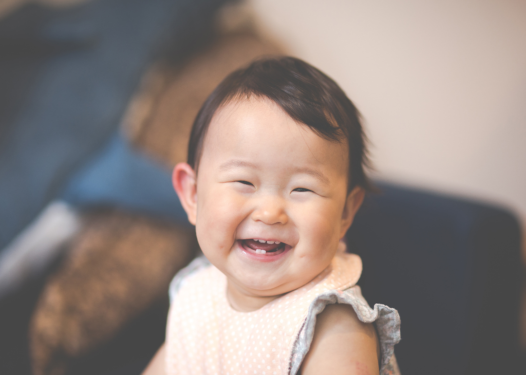 A laughing baby girl with two new bottom teeth.