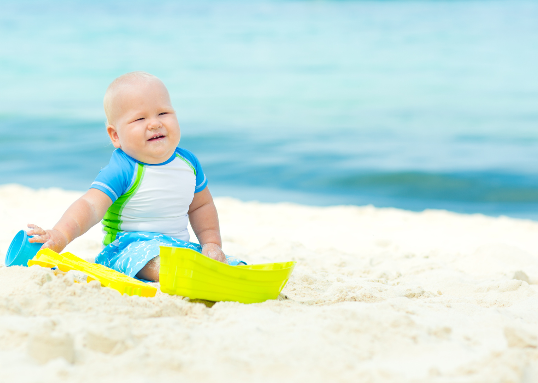 A little boy in the sand on the beach.