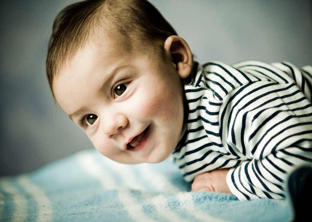 A smiling baby boy in a striped shirt.