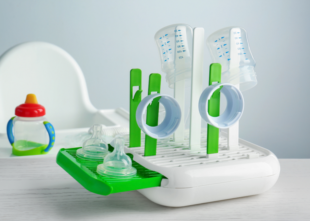 Baby bottles and parts on a drying rack.