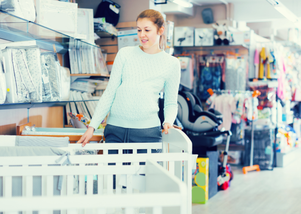 Woman shopping for baby crib and bedding.