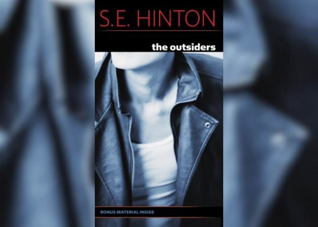 A black and white photo of a person's torso in a leather jacket and white shirt.