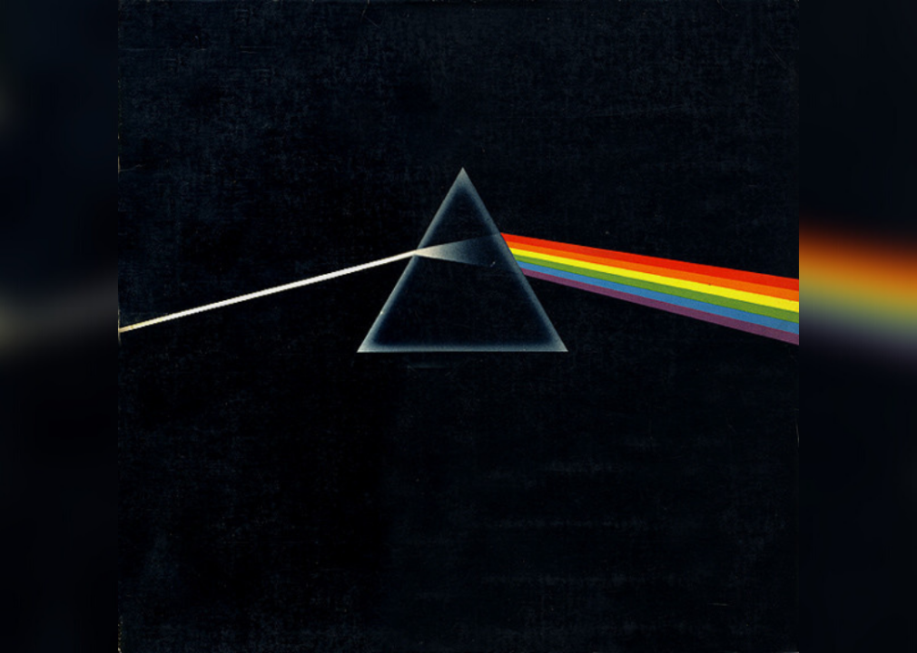A triangle with a rainbow prism of light coming out of one side against a black background.