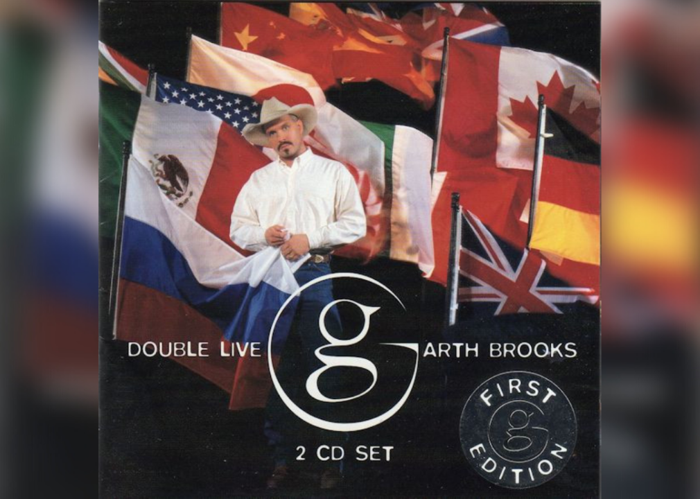 Garth Brooks in front of flags from many different countries.