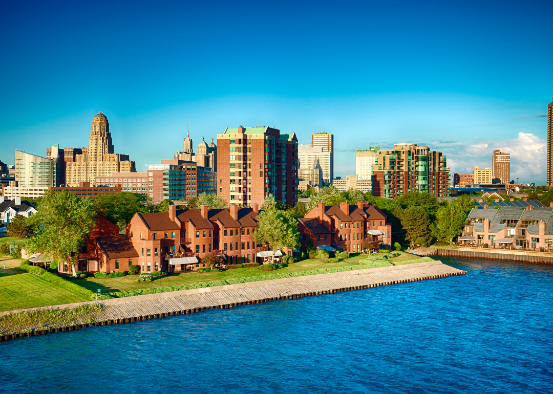 Buildings and homes on the water with the skyline in the background.