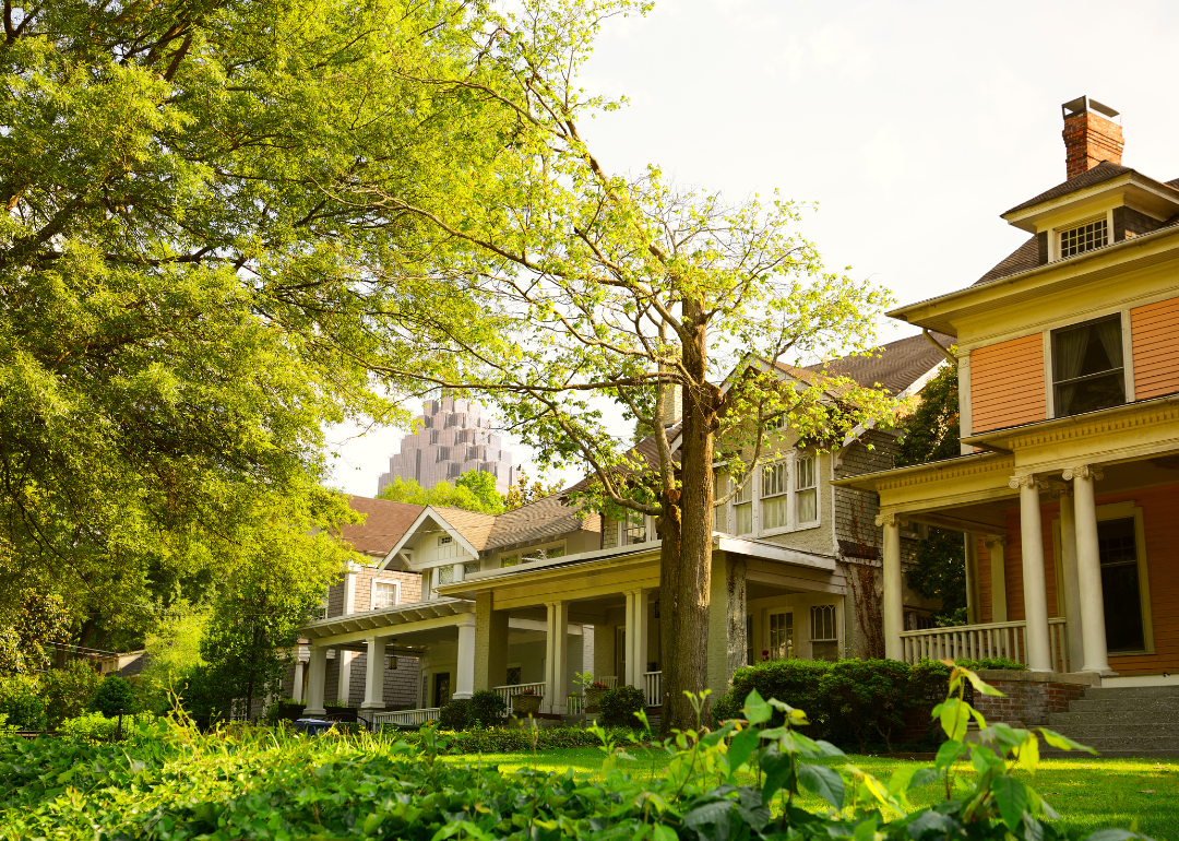 Historic homes with downtown buildings in the background.