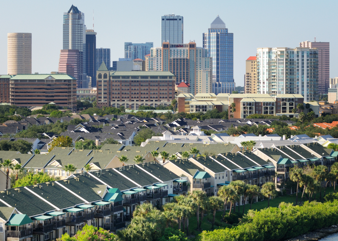 Homes on the water with the skyline in the background.