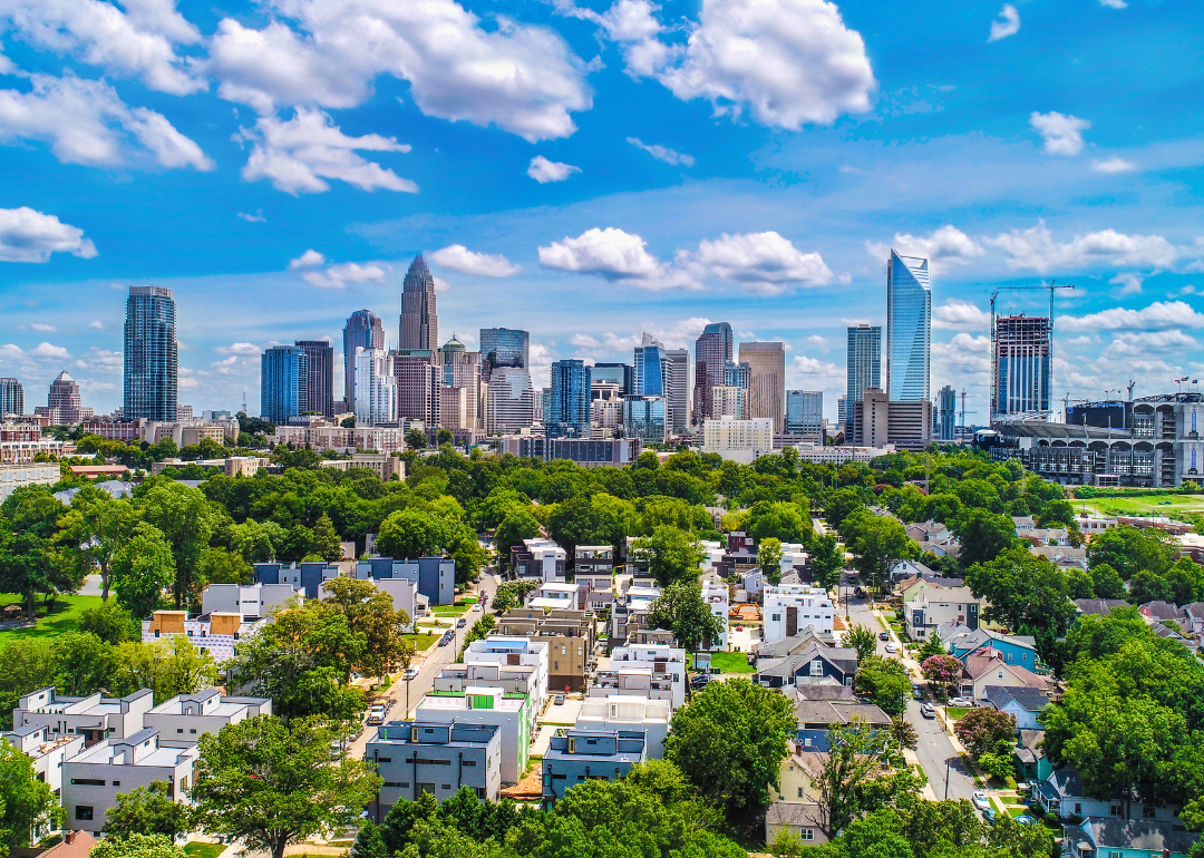 An aerial view of homes and the downtown skyline on a sunny day.