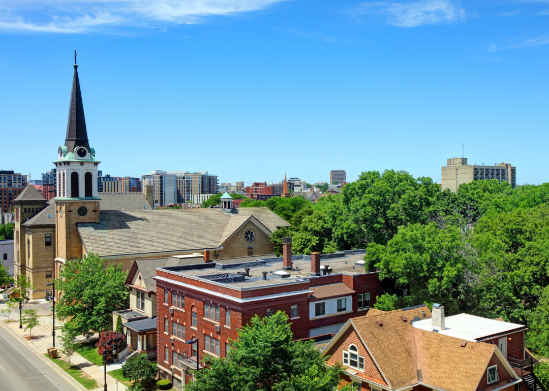 Homes and churches downtown with buildings in the distance.