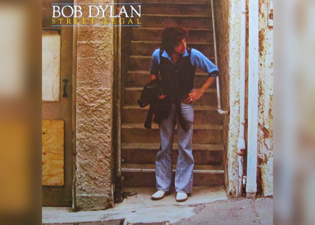 Bob Dylan at the bottom of a set of stairs looking around a corner.