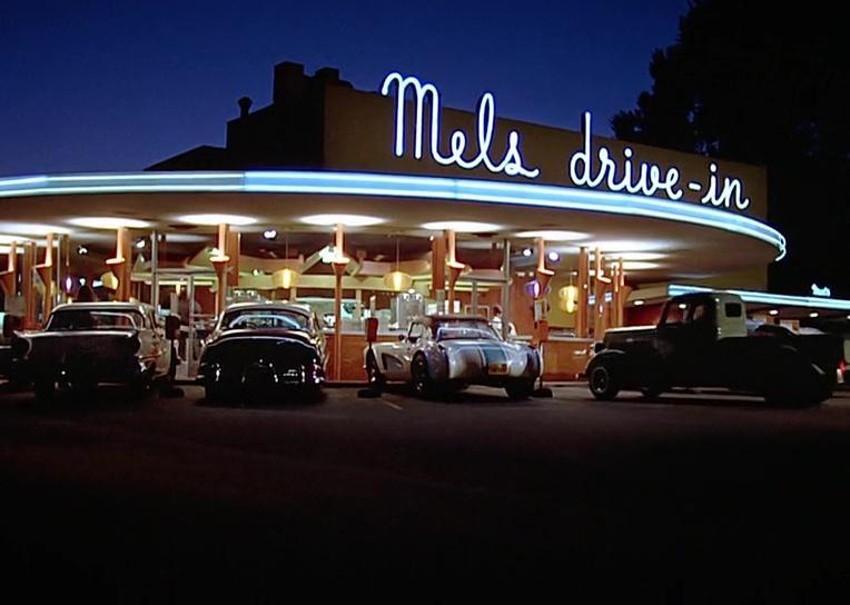Cars are parked outside Mel's Diner in a scene from ‘American Graffiti.'