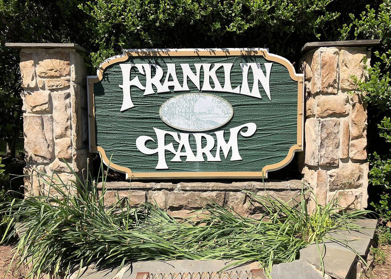 A brick and green Franklin Farm sign.