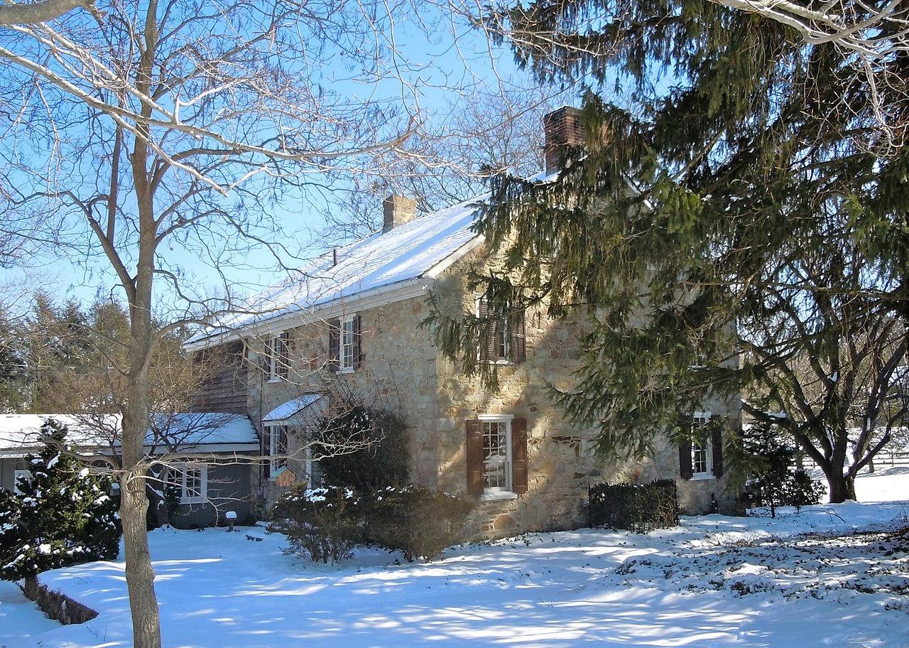 A stone home in the snow.