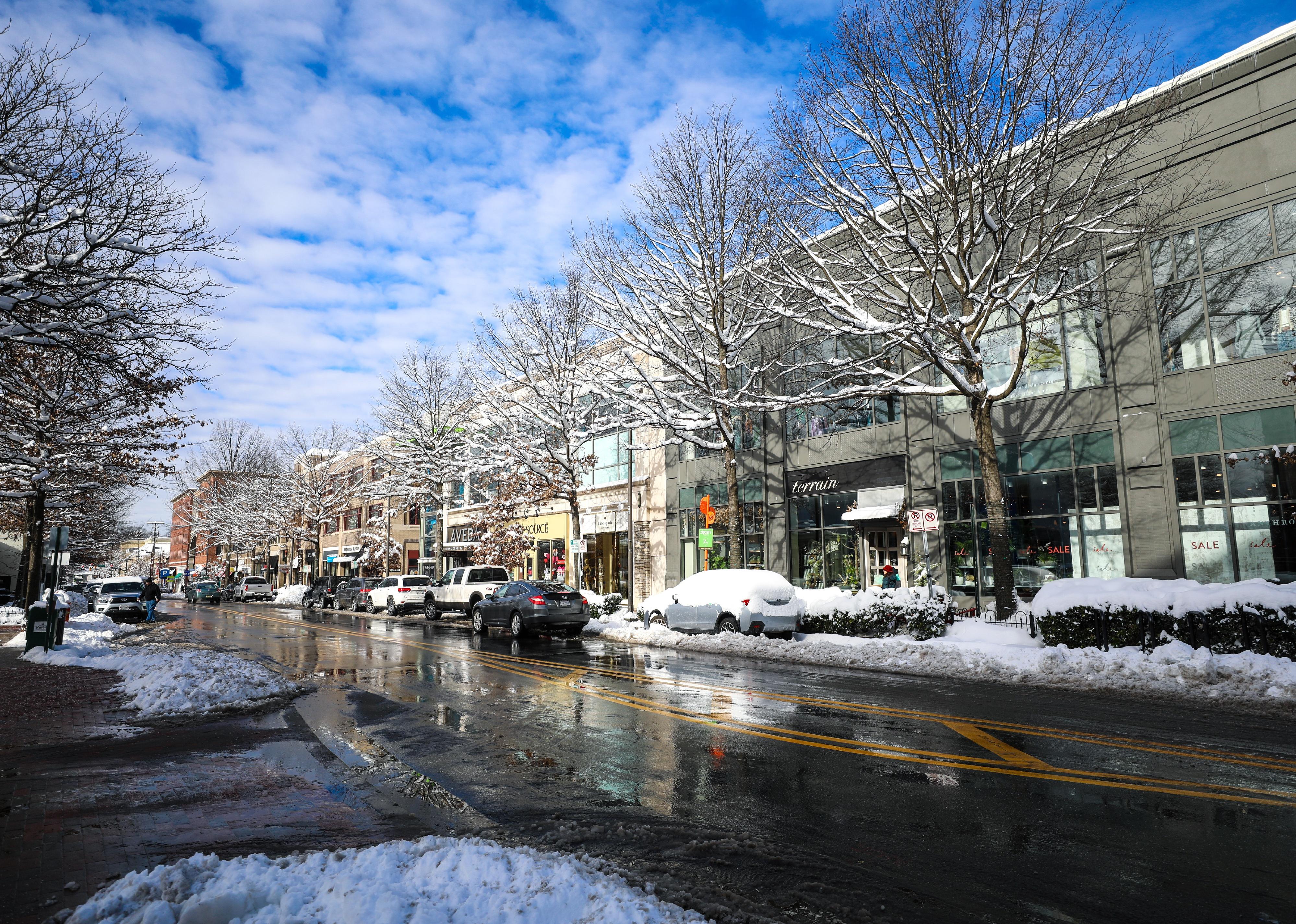 A snowy street lined with businesses.
