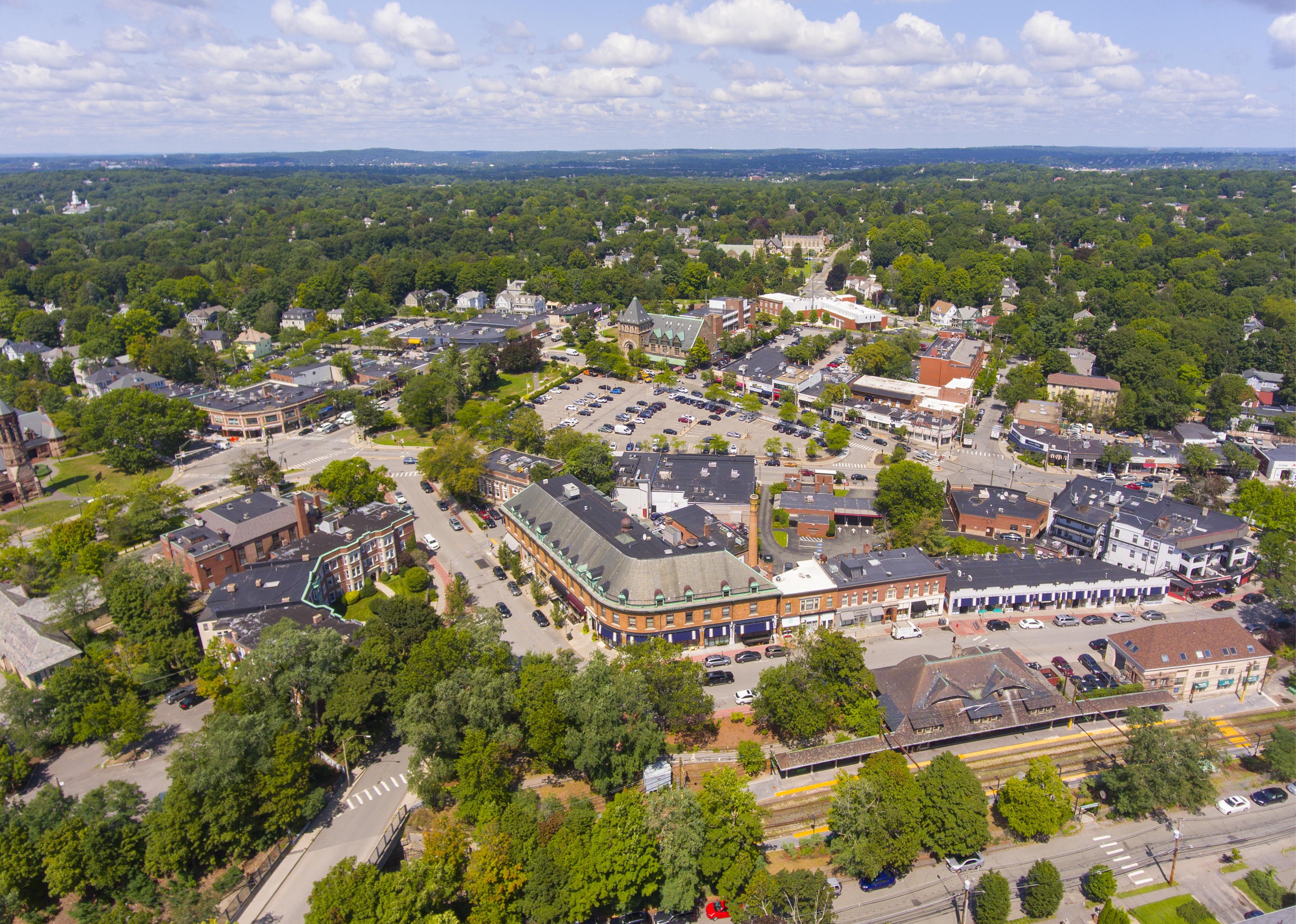 A large shopping center surrounded by trees and homes.