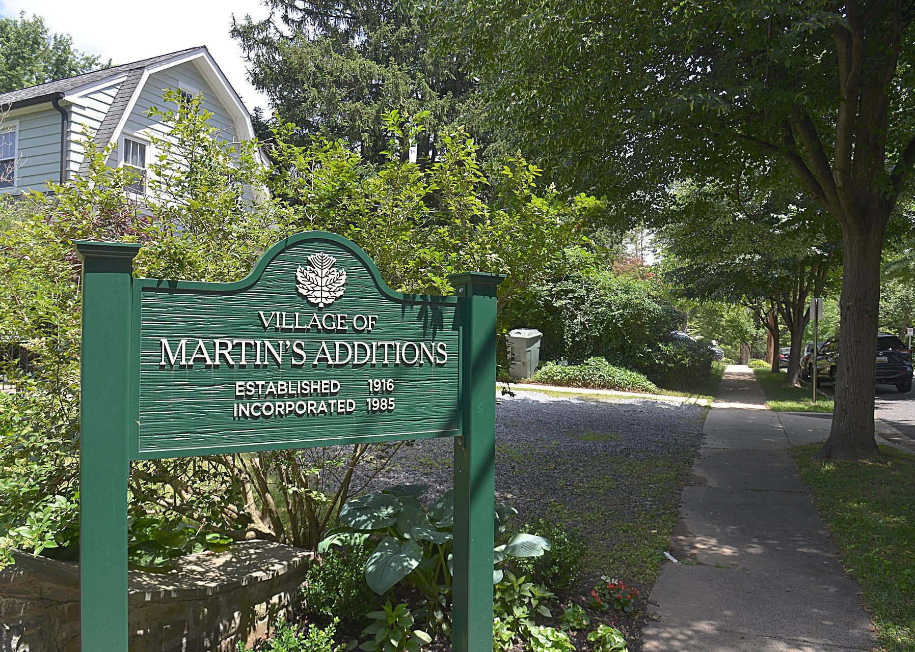 A green sign for Martin's Additions in a neighborhood.