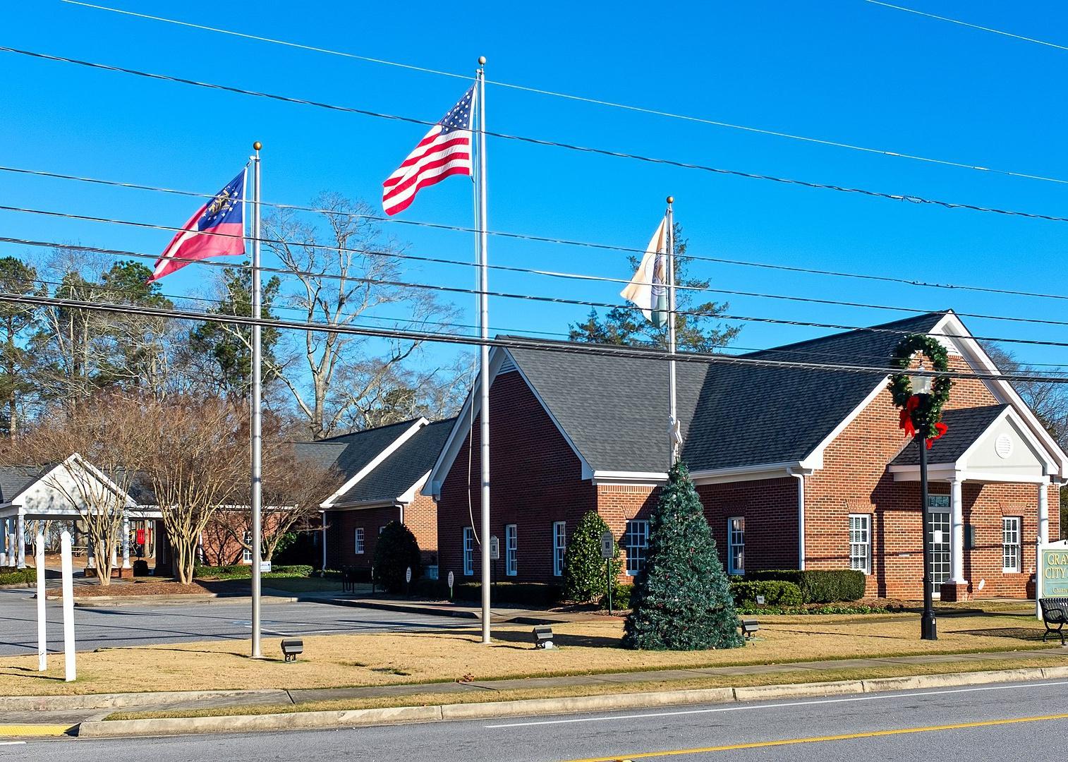 A brick building with flags on the front lawn.