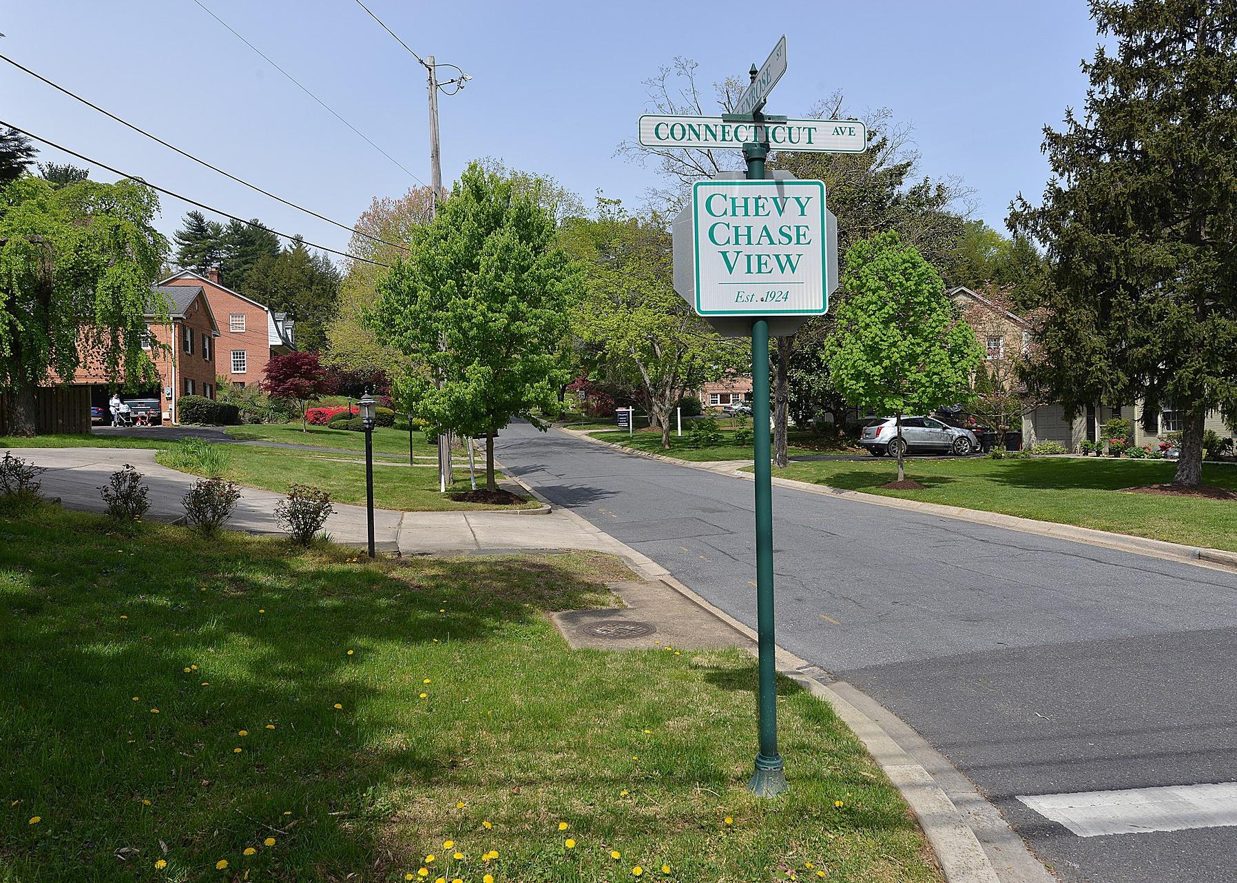 A neighborhood with large homes and a Chevy Chase View entrance sign.