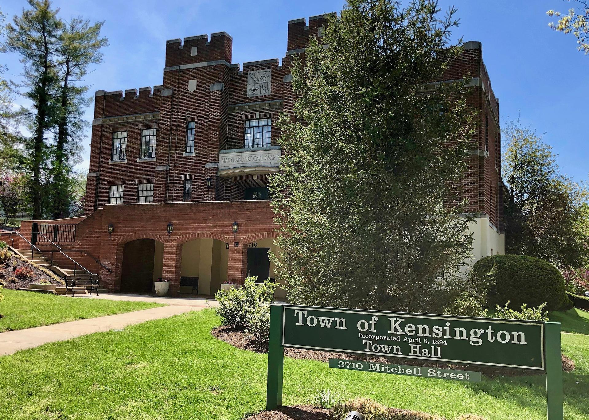 A red brick town hall with a green Kensington sign.