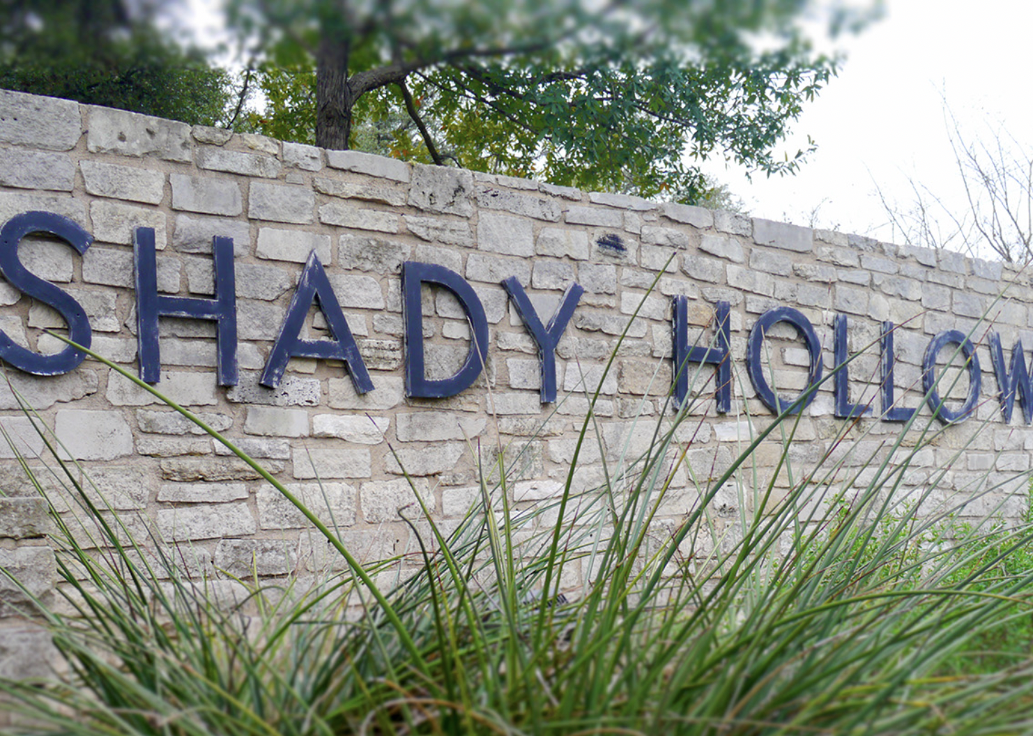 A brick sign for Shady Hollow.