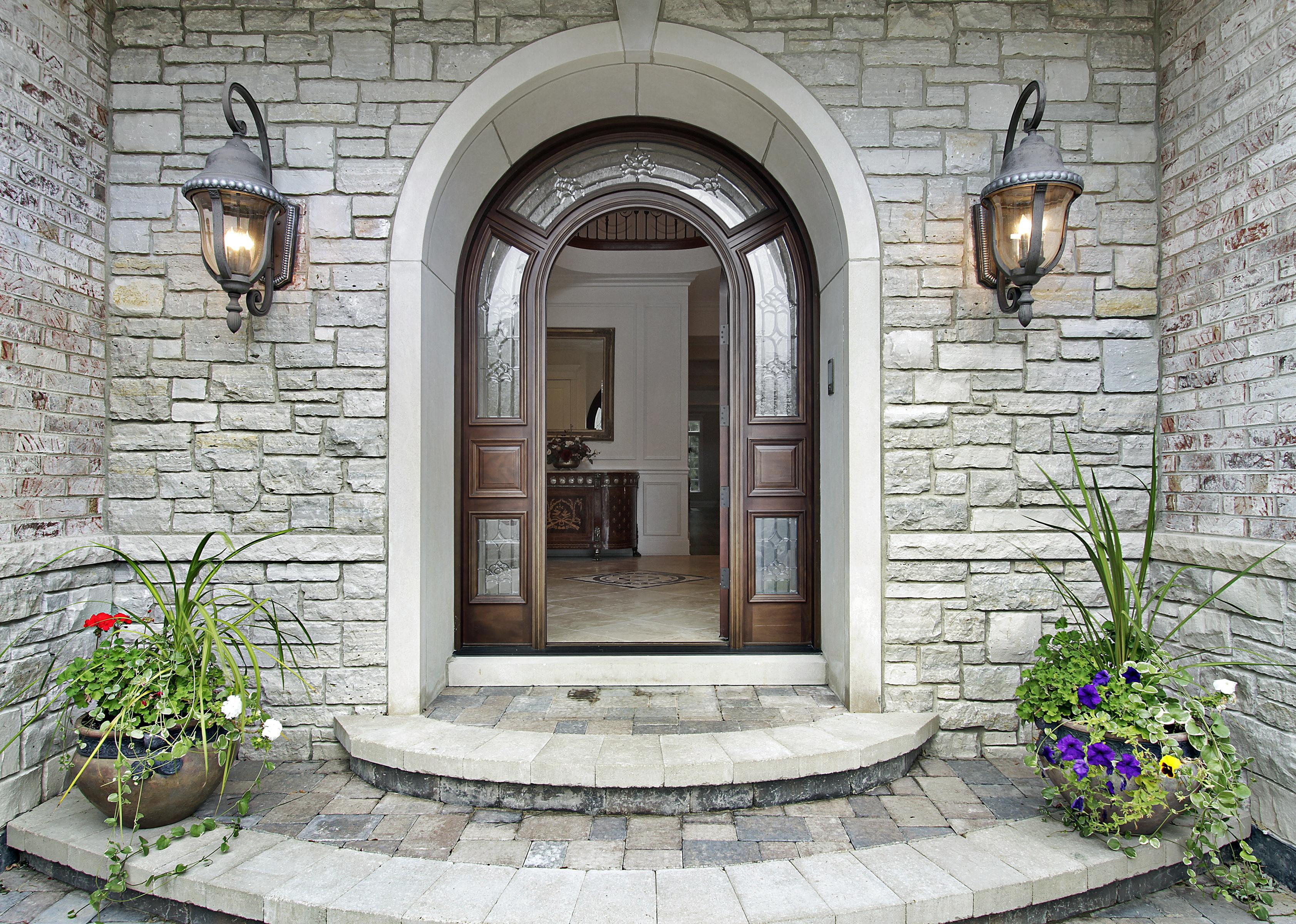 The grand open front door into a light-colored brick mansion.