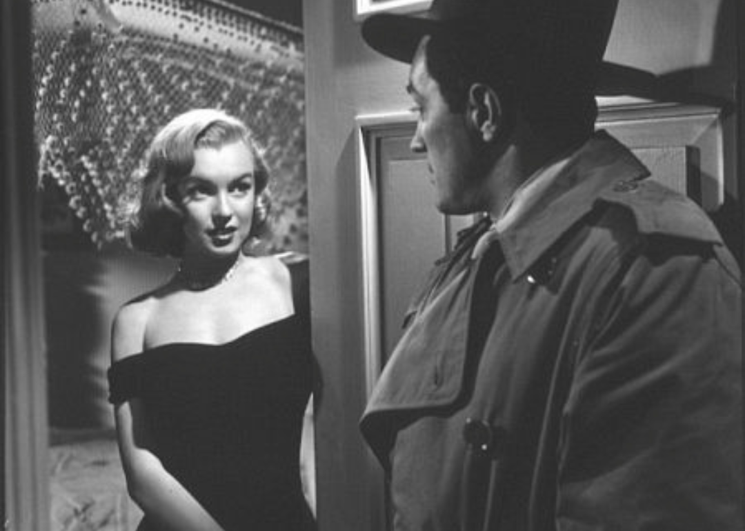 Marilyn Monroe answering the door to a man in a coat and hat.