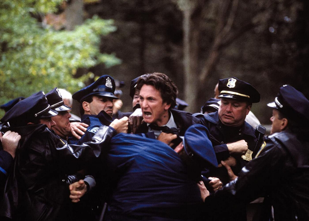 Sean Penn yelling and being held back by police officers.