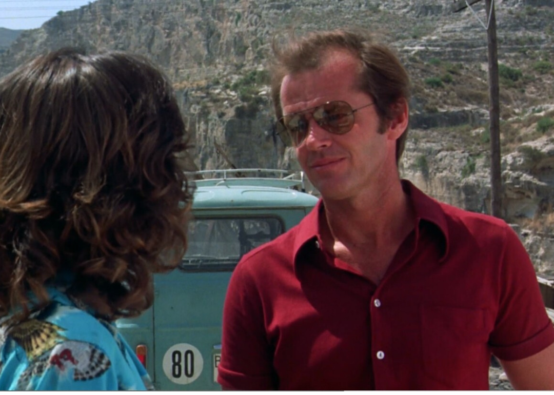 Jack Nicholson smiling at a dark haired woman in front of a mint green van.