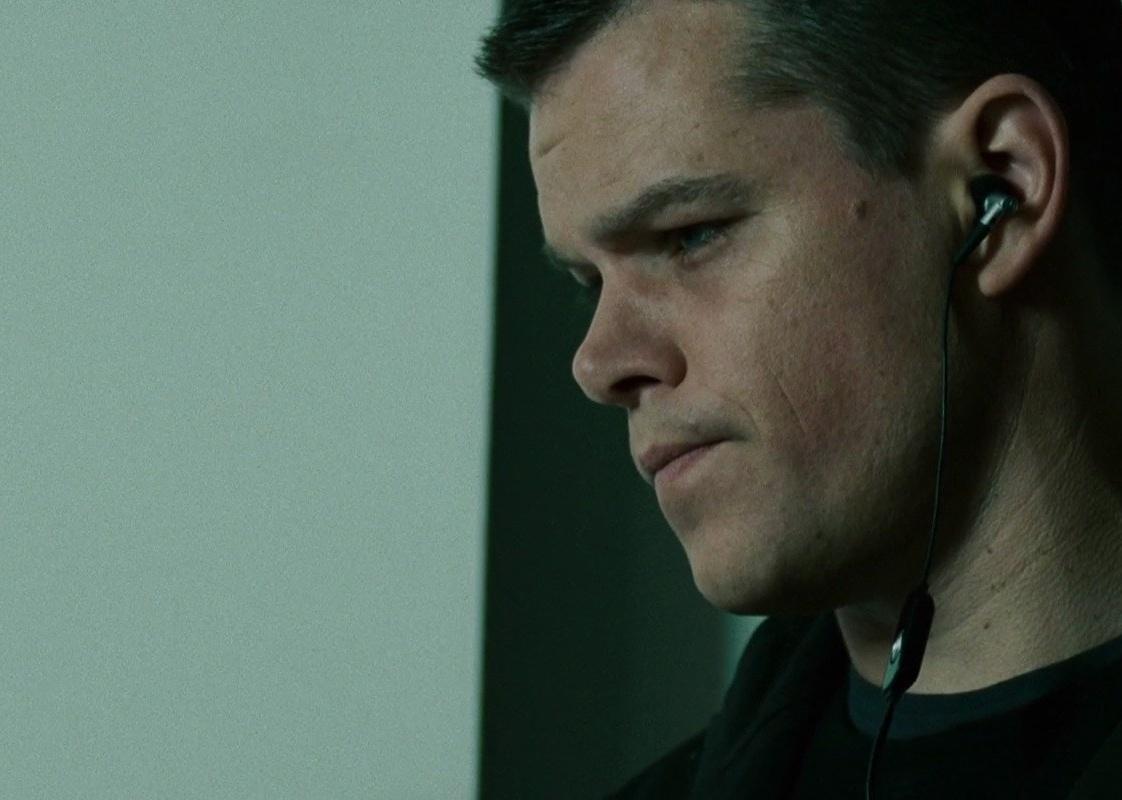 Matt Damon with a serious look on his face wearing headphones.