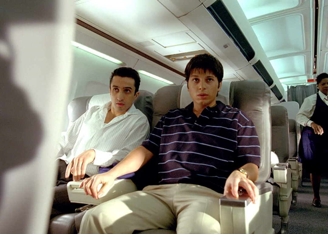Two young men look worried on an airplane.