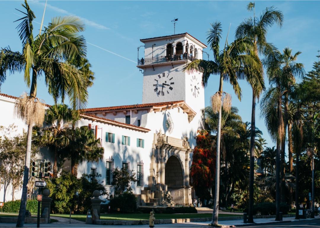 A white mission style building with a clocktower on top.
