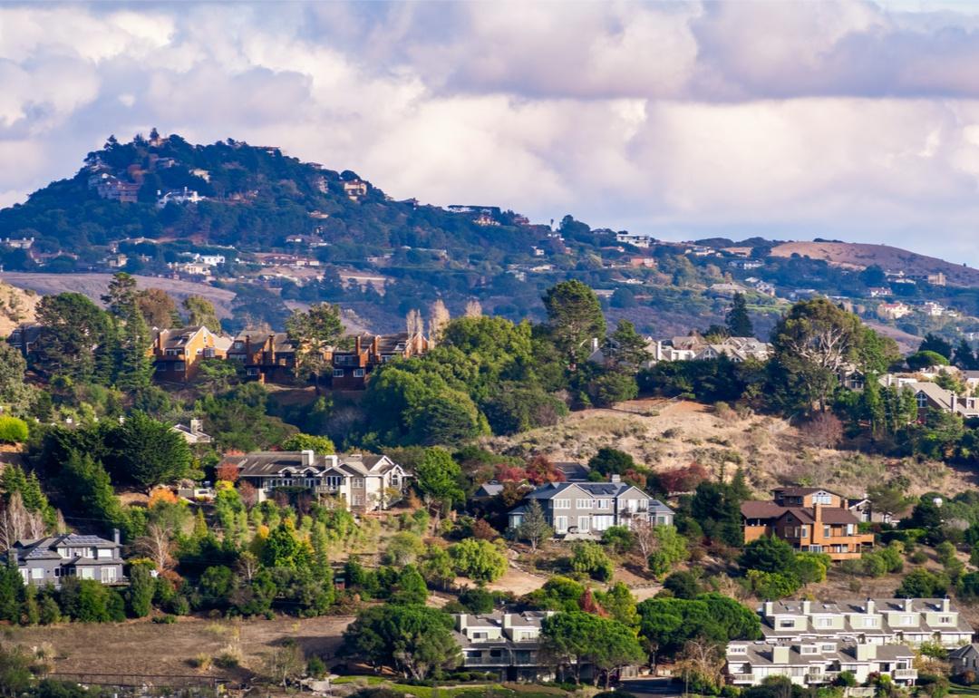 Large homes on a steep terrace up the green mountain.