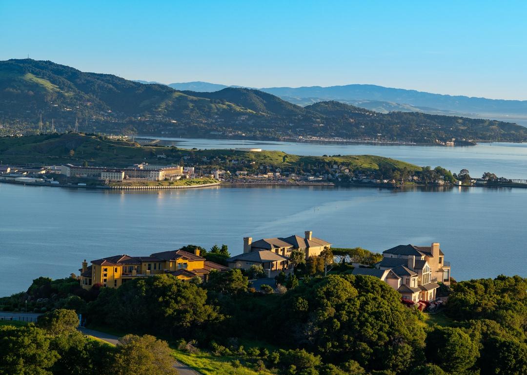 Large homes on the water on low mountain hills.